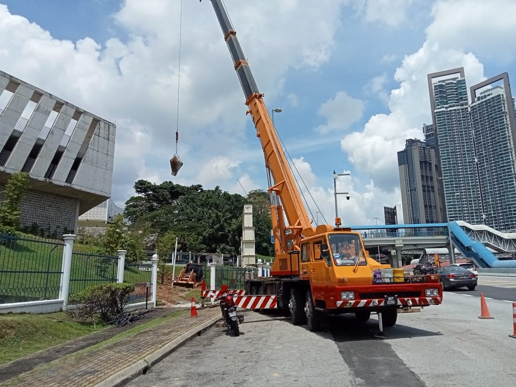 Mobile crane lifting LED billboard structure into place
