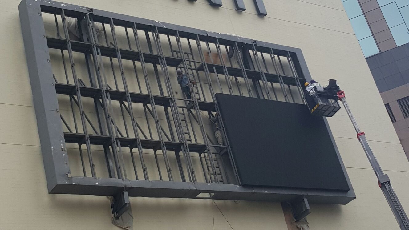 Outdoor LED cabinet being lifted into its frame